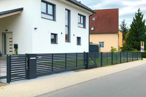 Eine komplette Zaunanlage aus der Schmuckzaun-Reihe MODERN. Integriert sind Schiebetor, Multibox und Pforte.